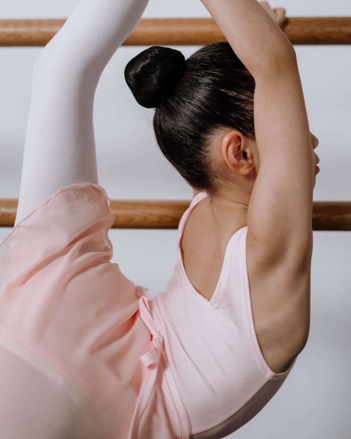 A young dancer at the barre, seen from behind