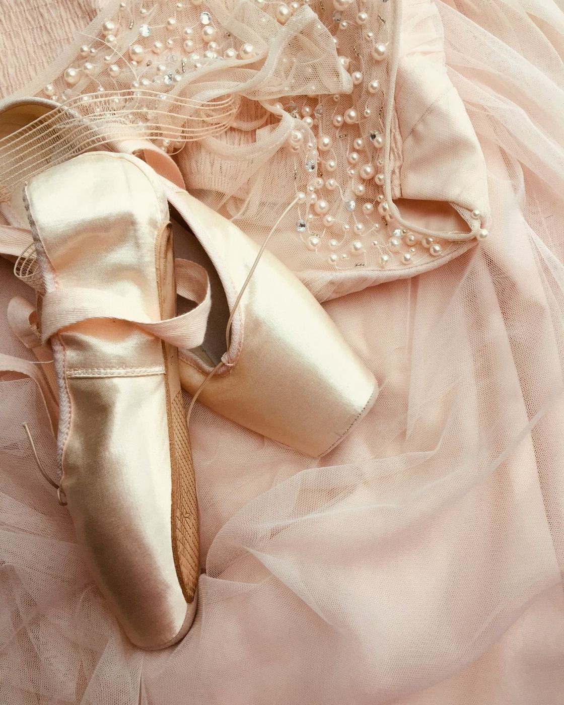 Pointe shoes resting on a pearl-embroidered tutu
